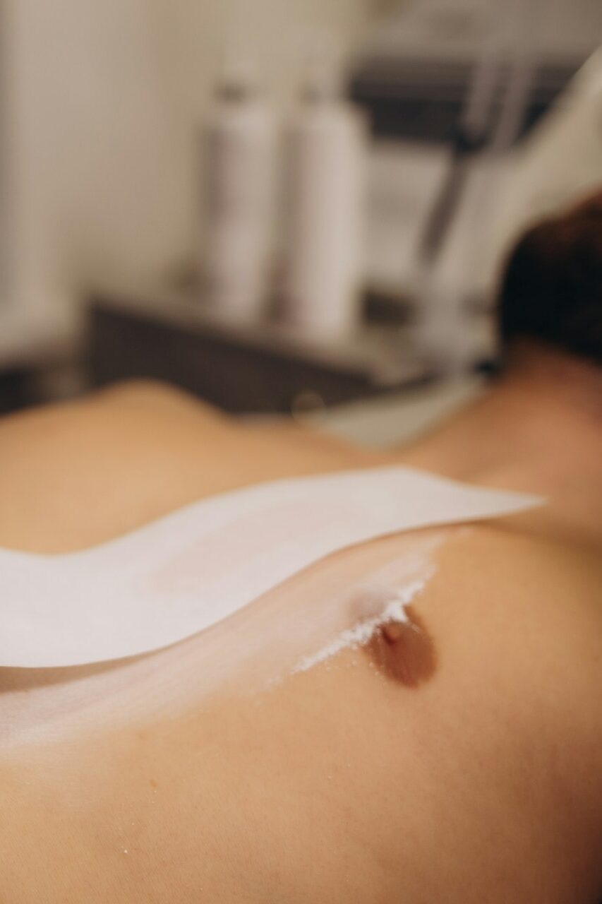 Close up of hairy chest of a man using wax epilation at home. Body Hair Removal Wax Warmer