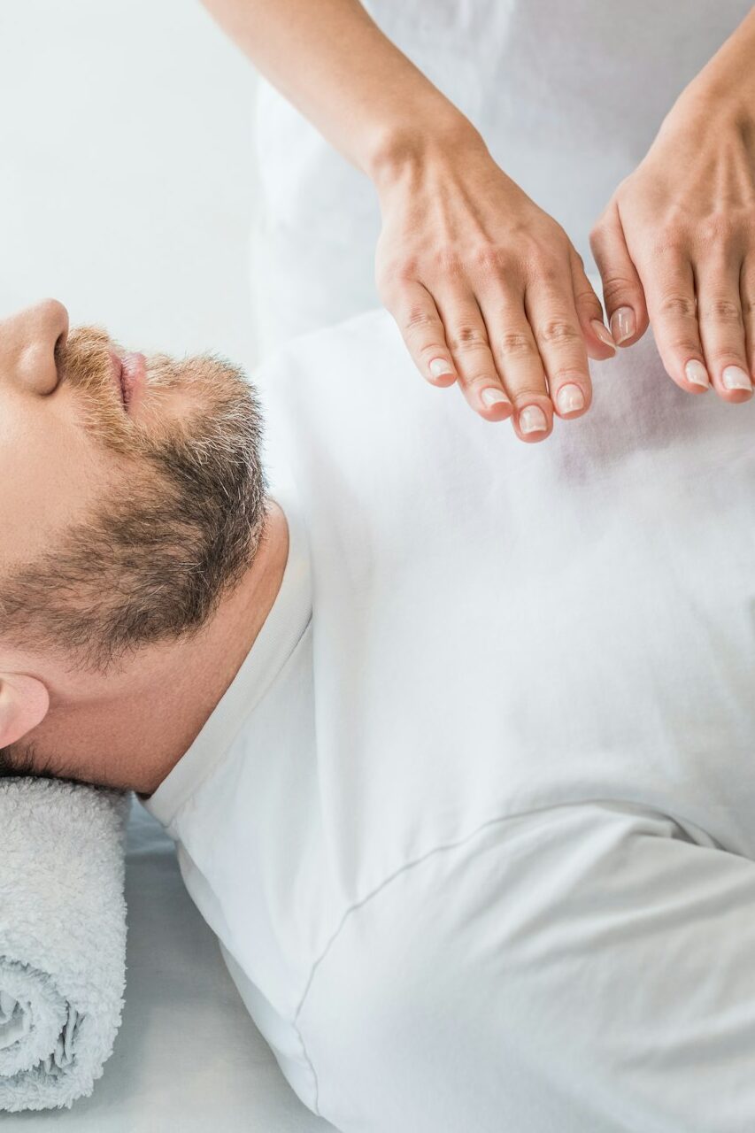 high angle view of bearded man receiving reiki treatment