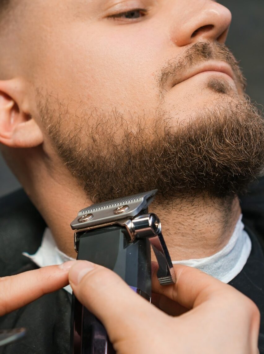 Man during the procedure of cutting beard.